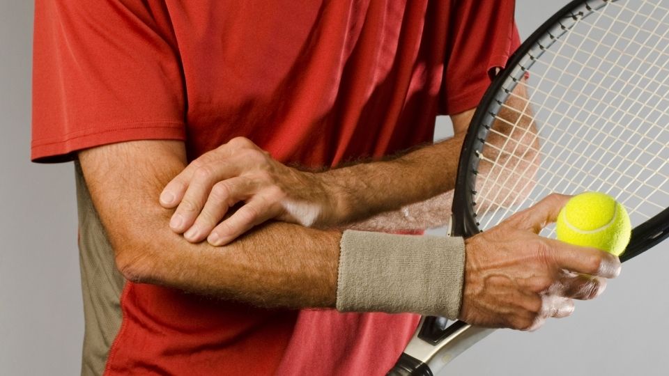 Man with tennis racket and elbow pain