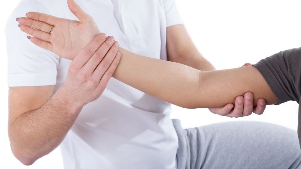 Man receiving physio care for elbow pain
